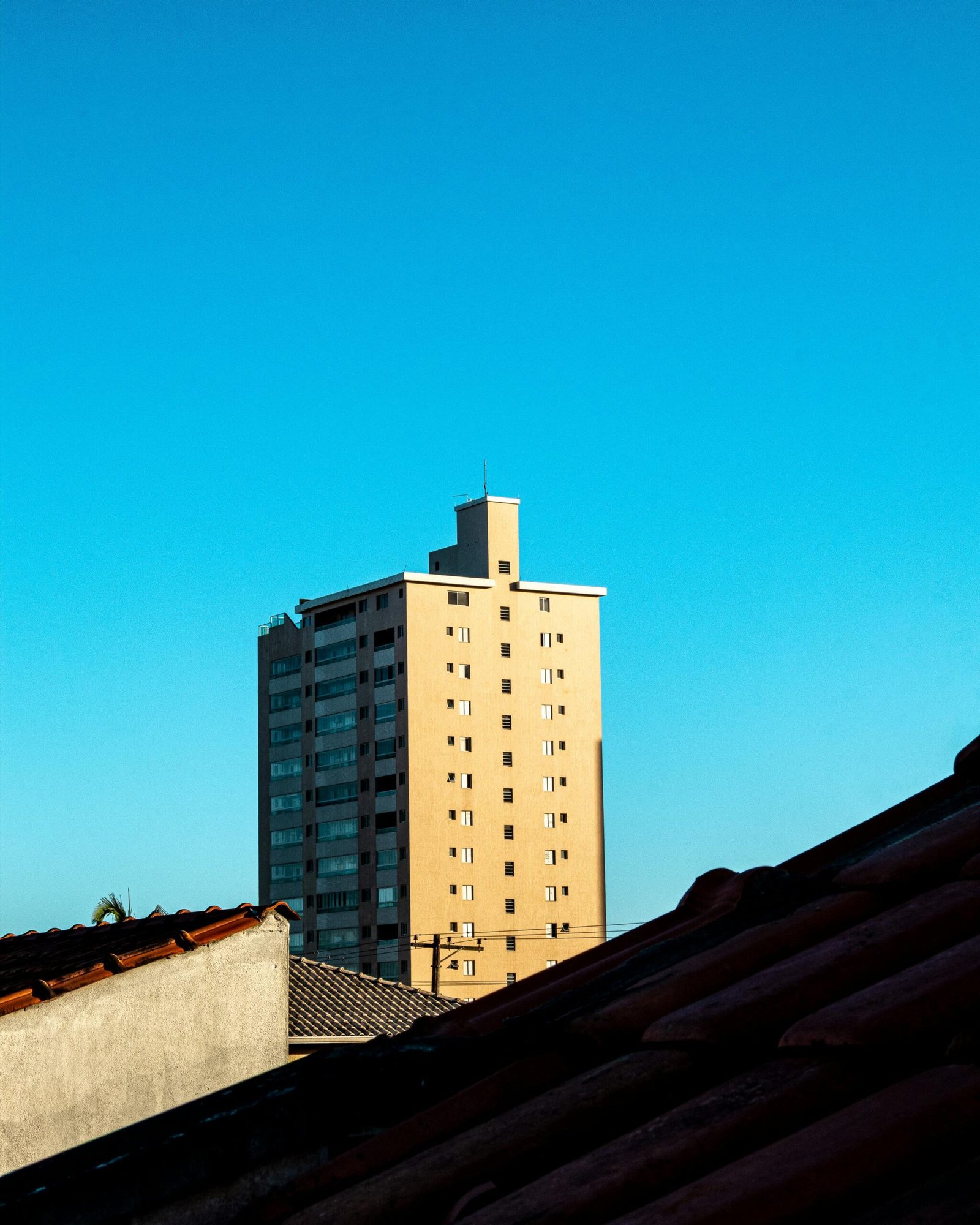 Cityscape featuring a high-rise building against a clear blue sky, capturing urban architecture.